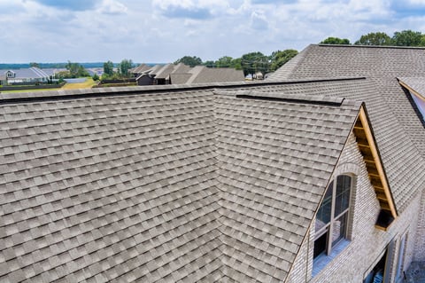 View new roofing on homes, surrounded by lush greenery under works area in suburban landscape